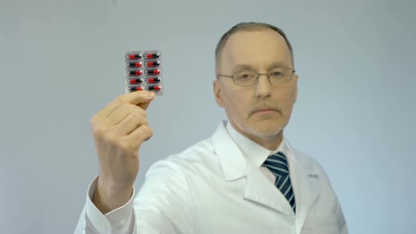 Confident Therapist Holding Package of Pills, Recommending Effective Drugs alt