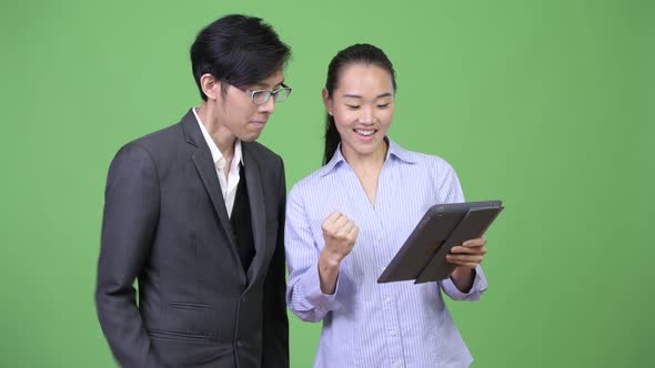 Young Asian Business Couple Getting Good News Together