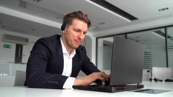 A Caucasian Businessman Watches an Interesting Webinar on a Modern Laptop Using Wireless Internet