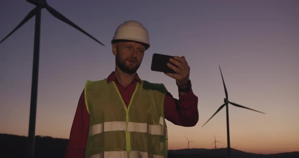 An Engineer at Sunset, Uses Video Communication To Achieve the Best Results in the Work. Green alt