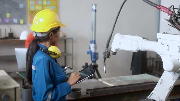 technical engineer manage keying programing movement of modern welding robot arm
