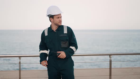 Port Worker Reporting About Status of Cargo By Walkie Talkie Radio While Working at Seaport alt