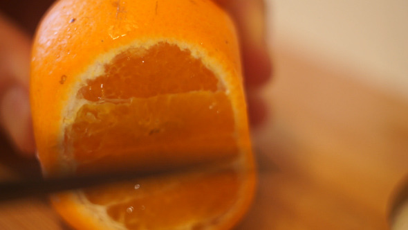 Cutting the Mandarin Into Slices Using A Knife 