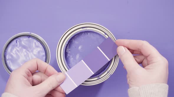 Close up of metal paint can with purple paint and paint swatch. alt