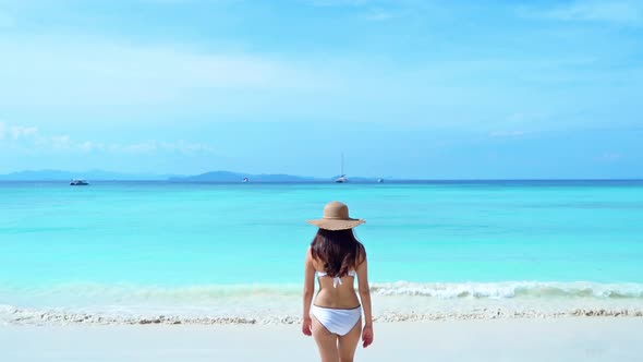 Happy Asian woman waking to the sea. Phuket Thailand alt