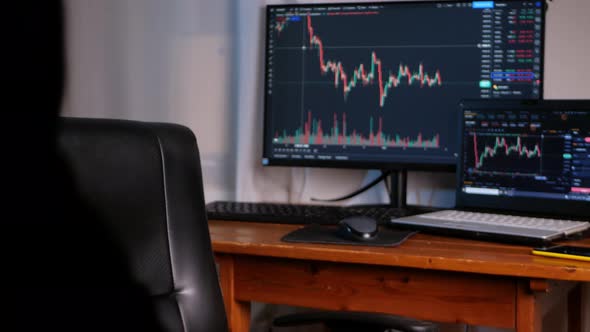 Cool Businessman in Dark Glasses Against Background of Monitors with Cryptocurrency Charts