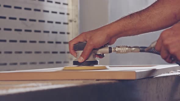 Slow motion of a worker polishing a cabinet door in a furniture factory alt