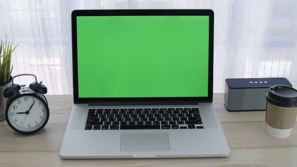 Chroma key green screen of laptop computer set on working space in home office alt