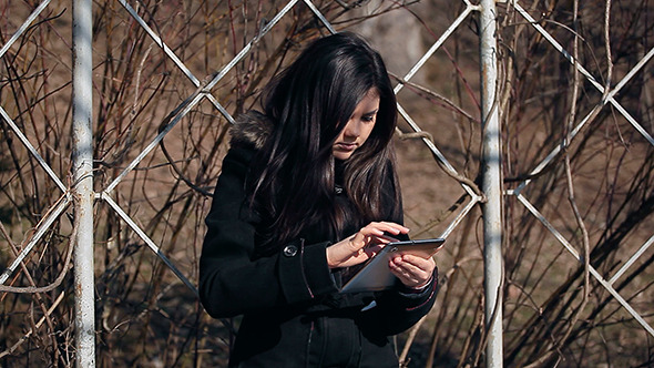 Young Woman Uses Tablet Computer Outdoor alt