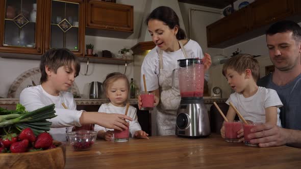 Children with Parents is Prepared a Smoothie at Domestic Kitchen and Drinking It