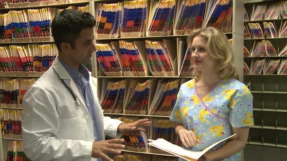 Nurse Hands Off Chart To Doctor