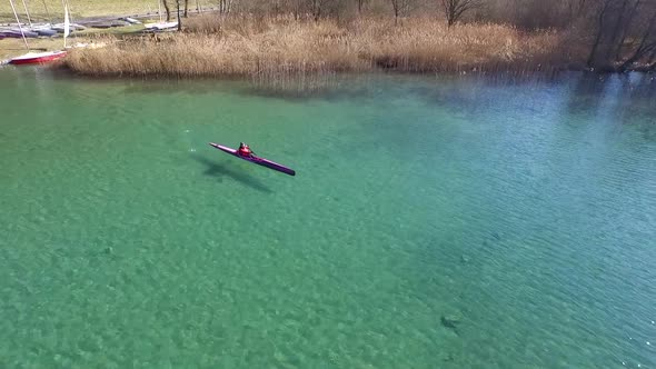 A kayaker paddles in a scenic mountain lake. alt