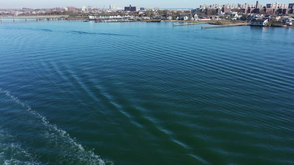 An aerial shot over Grassy Bay in Queens, NY. The camera, tilted down over the water, then tilts up alt