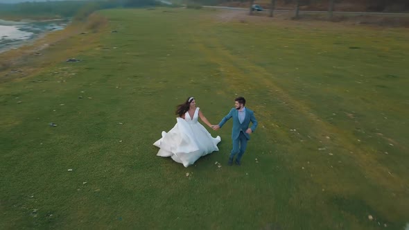Wedding Couple Running Near Mountain River, Groom and Bride, Arial View alt