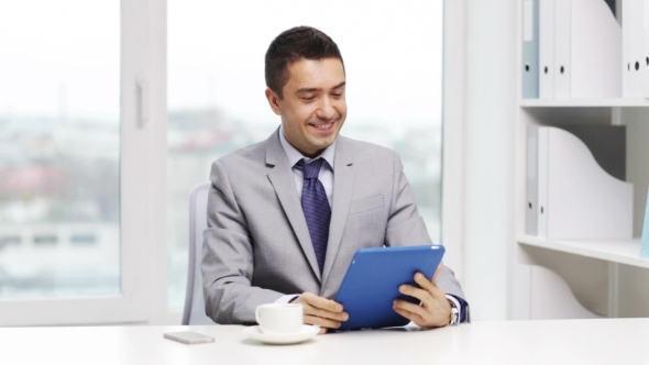 Smiling Businessman With Tablet Pc Drinking Coffee alt