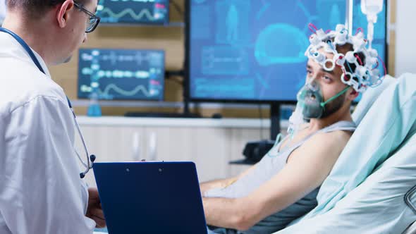 Patient with Brain Injury Reading From a Clipboard in Neurology Research Center alt