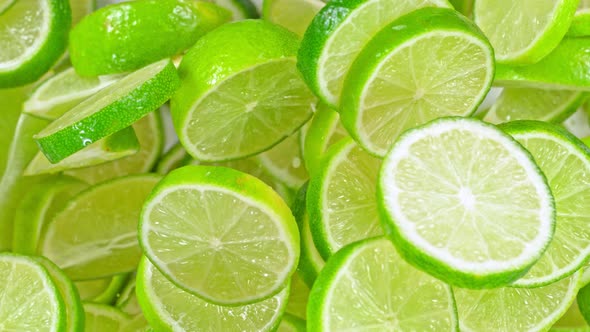 Super Slow Motion Shot of Flying Fresh Lime Slices Towards Camera at 1000Fps alt