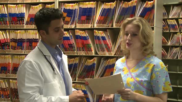 Doctor And Nurse Discuss Patient's Chart (3 Of 3)