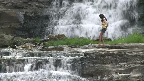 Young Girl Wading Across The Waterfalls