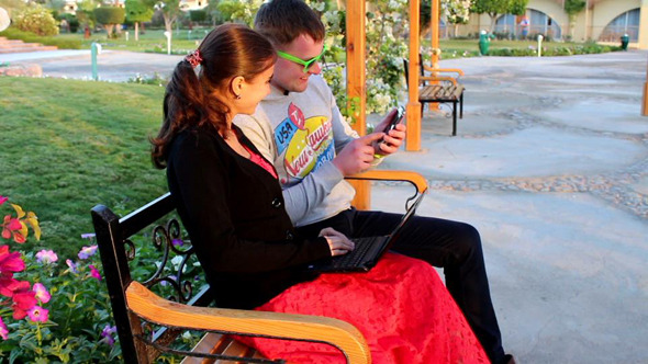 Couple Using  Smartphone and Laptop