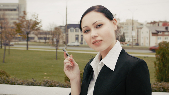 Young Woman Holding Pen With City Background