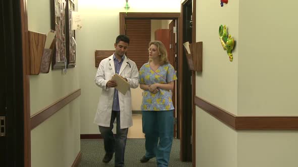 Doctor And Nurse Have Hallway Discussion (4 Of 6)