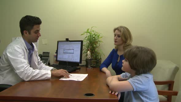 Male Doctor Consults With Mother And Son (3 Of 7)