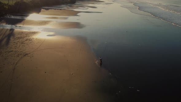 Adventurous Biker Riding on the Ocean Coast Aerial View alt
