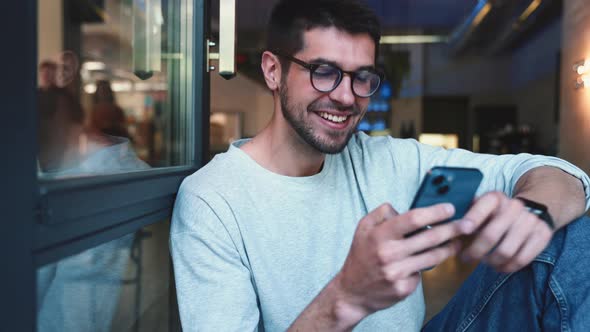 Cheerful man leafing tape by mobile alt