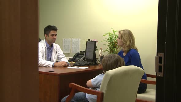 Doctor Has Office Discussion With Mother And Son