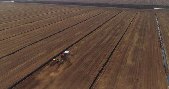 Peat Harvesting Aerial View with Tractor Working on Bog Field alt