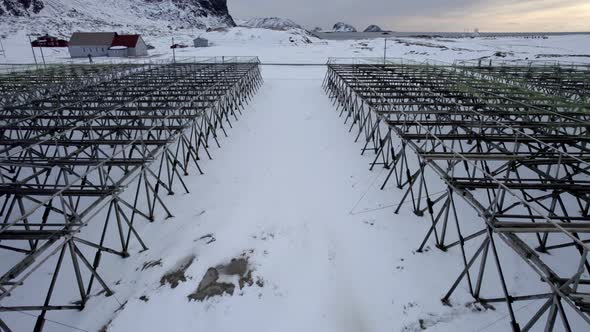 Wooden dry fish rack, stativ at Hovden beach in Scandinavia, close up flyover aerial shot 4k. alt