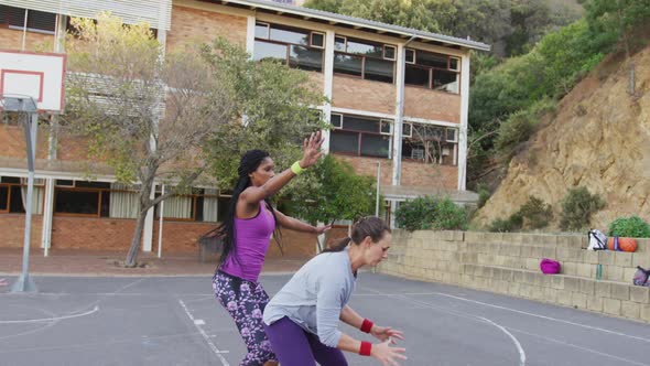 Diverse female basketball team playing match, dribbling and shooting ball alt