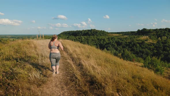 Overweight Girl Jogging in the Highlands in the Early Morning alt