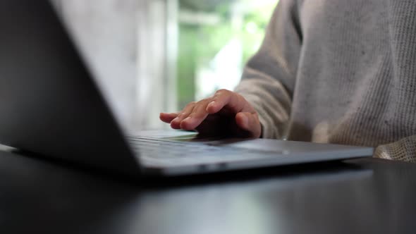 Closeup a woman working and touching on laptop computer touchpad on the table