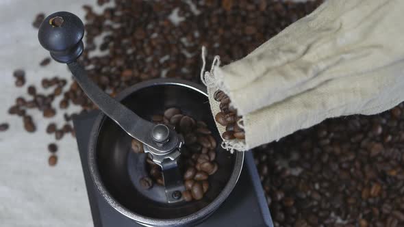Roasted Coffee Beans From a Bag Are Poured Into a Retro Coffee Grinder