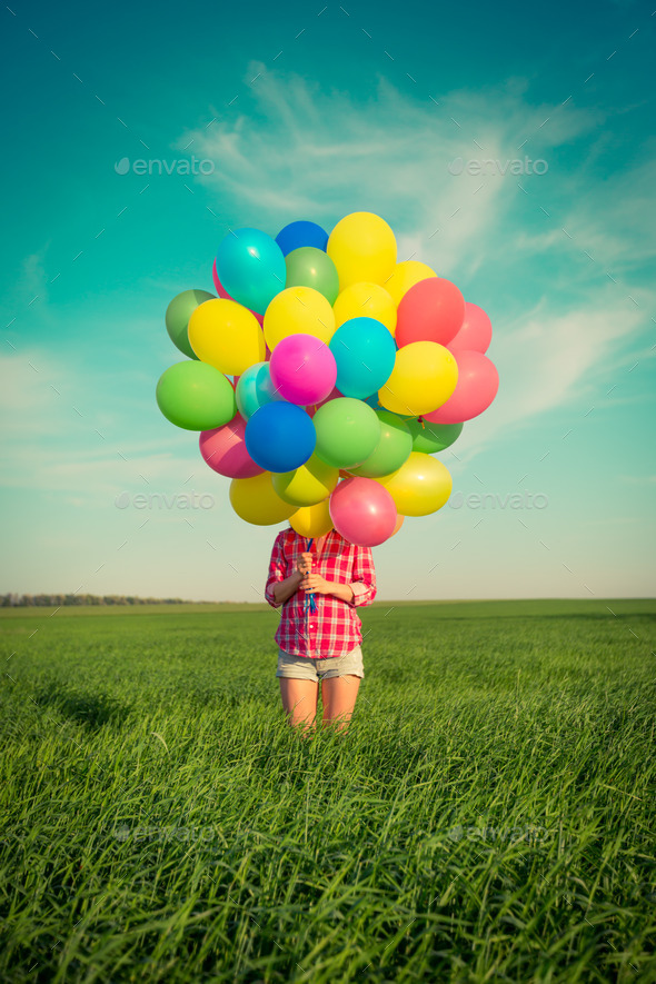 Woman with toy balloons in spring field - Stock Photo - Images