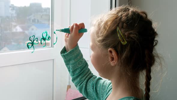 Drawing St.Patrick's Day Child painting green three-leaved shamrocks indoor Little girl draws clover alt