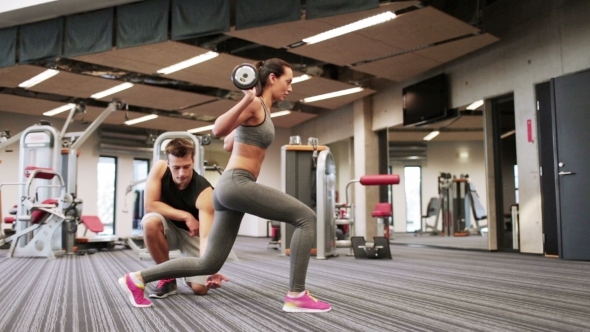 Man And Woman With Barbell Flexing Muscles In Gym alt
