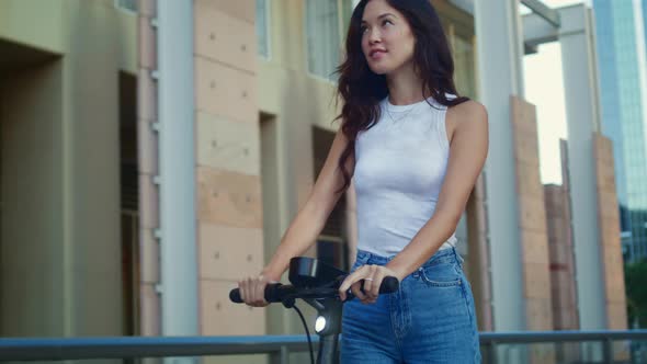 Carefree Woman Riding Scooter on Weekend alt