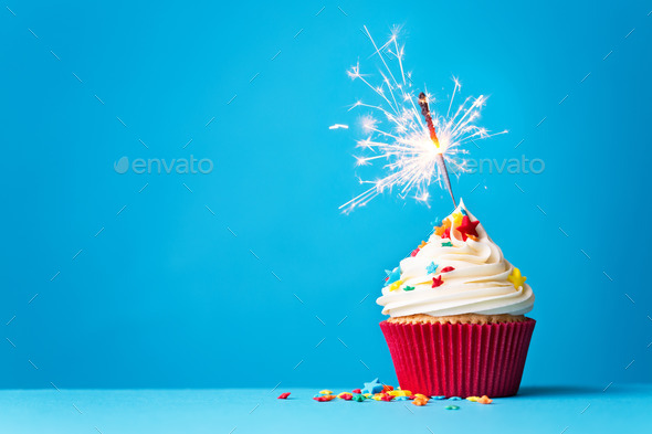 Cupcake with sparkler on blue - Stock Photo - Images