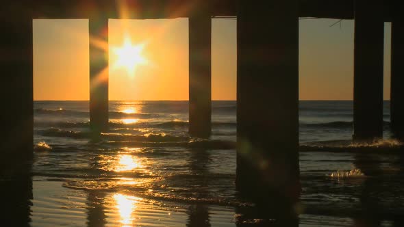View Of Sunrise Through Pier Moorings