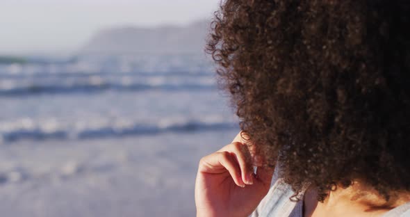 Close of up of african american with hand on chin smiling at the beach alt