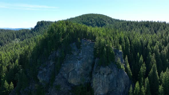 Aerial of a tree filled mountainous overlook at the end of a grueling hike; Oyster Dome in the Casca alt