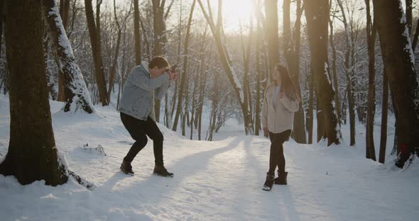 Happy Young Beautiful Couple Spend Time in Sunny Winter Forest Together