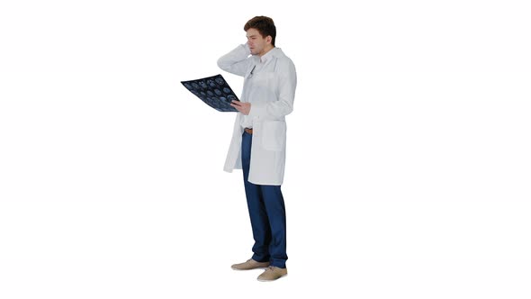 Frustrated Male Doctor Examining Computed Tomography Scan of Brain on White Background. alt