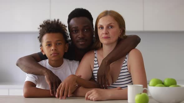 African Portrait of Young Dad Mom and Son are Smiling in Front of Camera at Table in Apartment Room alt