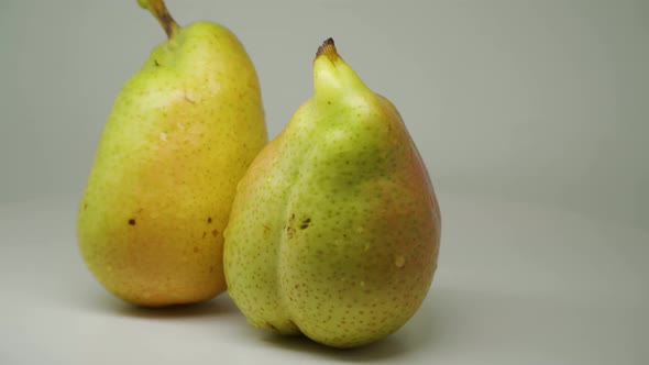 Two Delicious Freshly Picked Pear Rotating Clockwise On The Table - Close Up Shot alt