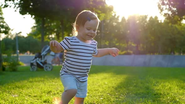 Cute Little baby girl walks by grass