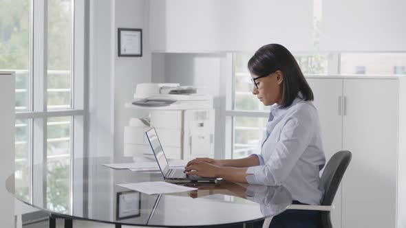 Portrait of Cheerful African Businesswoman Sitting at Table in Office and Looking at Camera alt